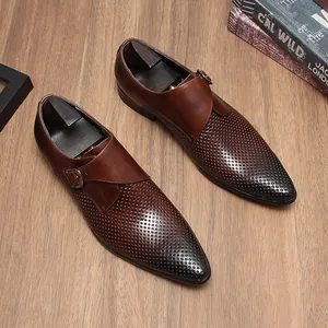 Gros plan sur des chaussures monk en cuir perforé marron sur une surface en bois