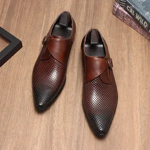 Détail de chaussures de ville marron en cuir perforé avec boucle et bout pointu