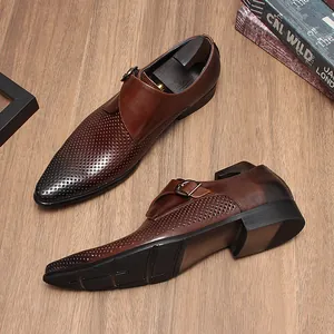Vue détaillée de chaussures monk en cuir perforé marron sur sol en bois