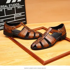 Détail de sandales romaines en cuir marron avec découpe tissée et boucle.