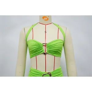 Close-up of lime green halter top featuring central metal ring detail on a dress form.