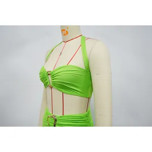 Close-up detail of sexy lime green halter two-piece set with gold heart buckle decoration