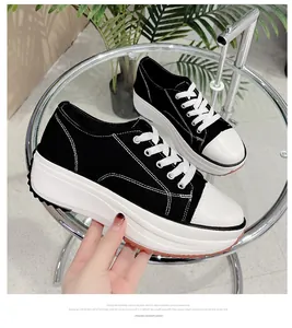 Close-up side view of women's black canvas sneakers with a thick white platform sole