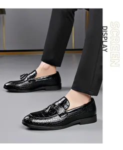 Close-up detail of men's black loafers with embossed crocodile pattern and tassel