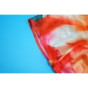 Detail of vibrant watercolor floral print and red piped hem on summer jumpsuit