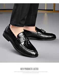 Detailed shot of black business loafers featuring crocodile texture and tassel accents.