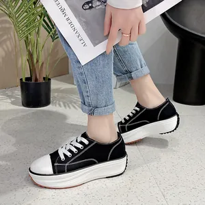 Women's black low-top platform canvas sneakers with chunky white soles and laces