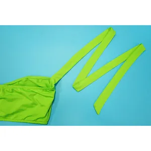 Detailed view of the vibrant neon green halter strap and swimsuit fabric texture
