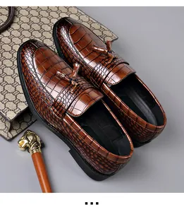 Detailed view of brown crocodile texture loafers with tassels and leather lining