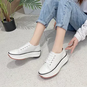 Stylish white platform low-top canvas sneakers for women with thick soles and lace-up closure.
