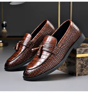 Close-up view of brown men's crocodile pattern loafers with elegant tassel detail