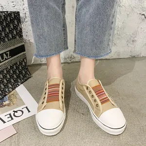 Close-up of casual canvas loafers with colorful elastic straps shown on foot