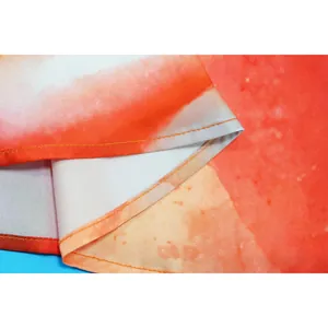 Close-up showing the precise orange stitching on a watercolor print jumpsuit hem.