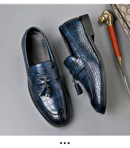 Macro view of blue crocodile embossed leather loafers with tassels for men's formal wear