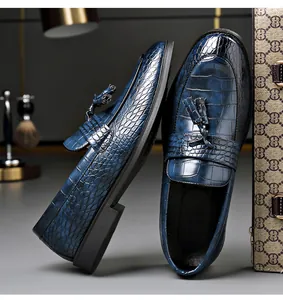 Detailed view of blue crocodile embossed leather loafers with stylish tassel accents