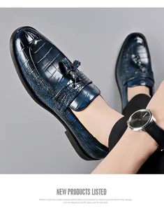 Close-up of blue crocodile embossed leather loafers with decorative tassels for men