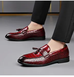 Side view of elegant men's burgundy crocodile pattern leather loafers with stylish tassels