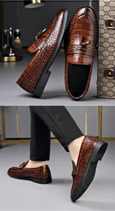 Macro view of brown crocodile texture leather loafers for men with stylish tassel detail