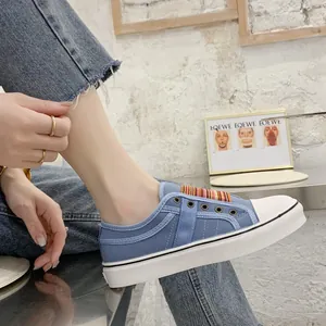 Detail view of women's blue canvas platform shoe featuring a colorful striped elastic band