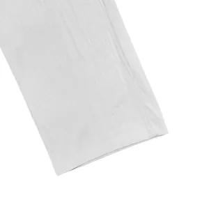 Close-up of white breathable linen trouser cuff showing fine fabric texture and stitching.