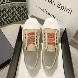 Detailed top view of retro beige canvas sneakers with colorful elastic bands in a box