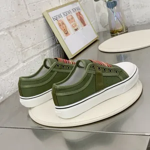 Detailed side view of olive green platform canvas sneakers with striped elastic band