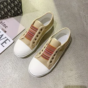 Detailed top view of tan canvas sneakers featuring colorful striped elastic bands.