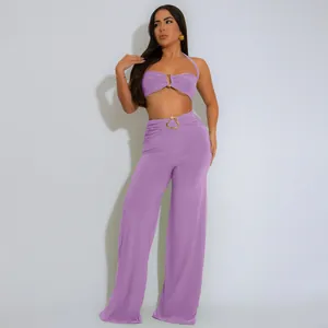 Detailed view of lavender halter crop top and matching wide-leg pants with gold buckles