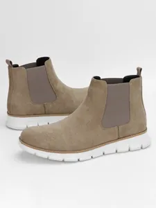 Detailed view of khaki suede Chelsea boots with lightweight white grooved soles