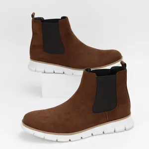 Detailed side view of men's brown suede Chelsea boots with lightweight white soles.