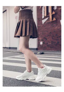 A detailed side view of chunky white platform sneakers with 8cm inner height increase