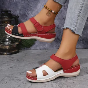 Vue détaillée de sandales compensées rouges avec design ajouré et attaches velcro pratiques