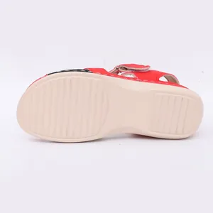 Vue détaillée de la semelle antidérapante beige texturée d'une sandale à talons compensés rouges