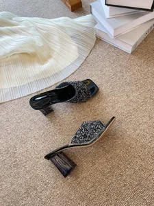 Dettaglio del cinturino in strass neri e del tacco largo trasparente sui sandali da donna