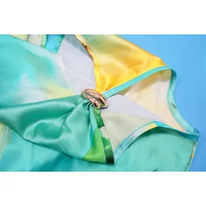 Macro detail showing the luxurious satin fabric and rose gold buckle of this printed jumpsuit