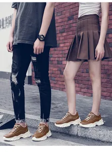 Detail of couple wearing trendy brown platform dad sneakers with 8cm thick soles.