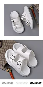 Detailed top view of white double-buckle men's slides on a professional grey background