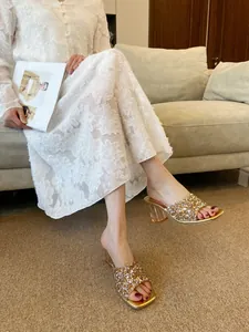 Eleganti ciabatte da donna con strass dorati e tacco a blocco trasparente indossate