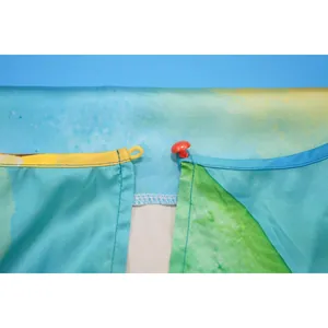Close-up detail of red button and elastic loop closure on vibrant printed jumpsuit fabric