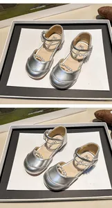Nahaufnahme silberner Mädchenprinzessinnenschuhe mit eleganten Perlenriemendetails