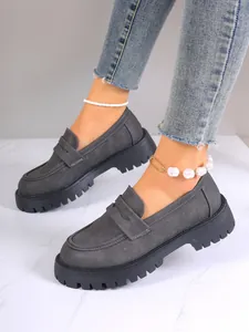 Close-up of grey chunky platform loafers with suede-like texture and thick soles
