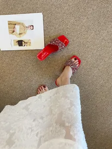 Sandali rossi con strass e tacco largo mostrati in un elegante ambiente lifestyle