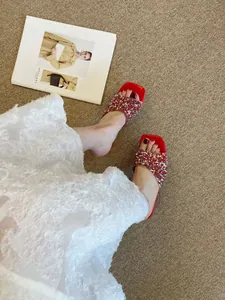 Eleganti sandali rossi con strass, punta quadrata e tacchi alti trasparenti.