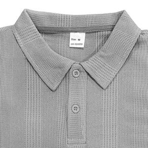 Primer plano del cuello de un polo gris texturizado con etiqueta de poliéster talla M
