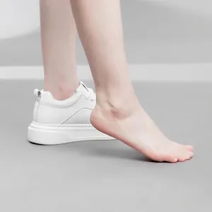 Minimalist white platform sneakers with thick soles for a casual, fashion-forward look