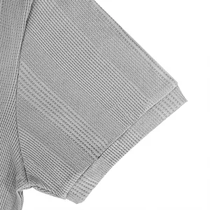 Detalle de cerca del tejido transpirable gris de un polo de manga corta para hombre
