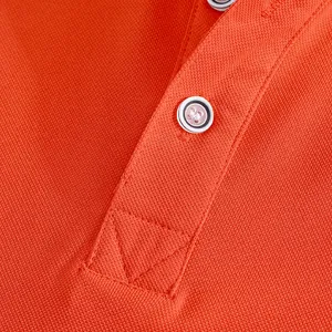 Macro detail of orange mesh polo shirt showing breathable fabric texture and buttons