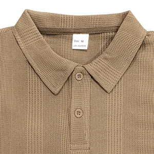 Primer plano del cuello de un polo caqui de punto gofrado con una etiqueta talla M