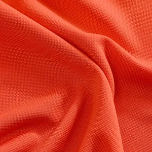 Close-up detail of high-quality bright orange breathable mesh fabric for men's polo shirt