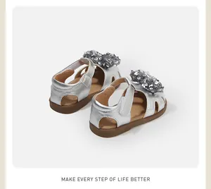 Nahaufnahme von silbernen Kleinkindsandalen mit glitzernden Pailletten-Schleifen